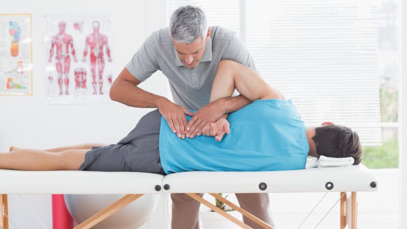 Rwa kulszowa udowa - pacjent leżący na łóżku podczas rehabilitacji kręgosłupa.